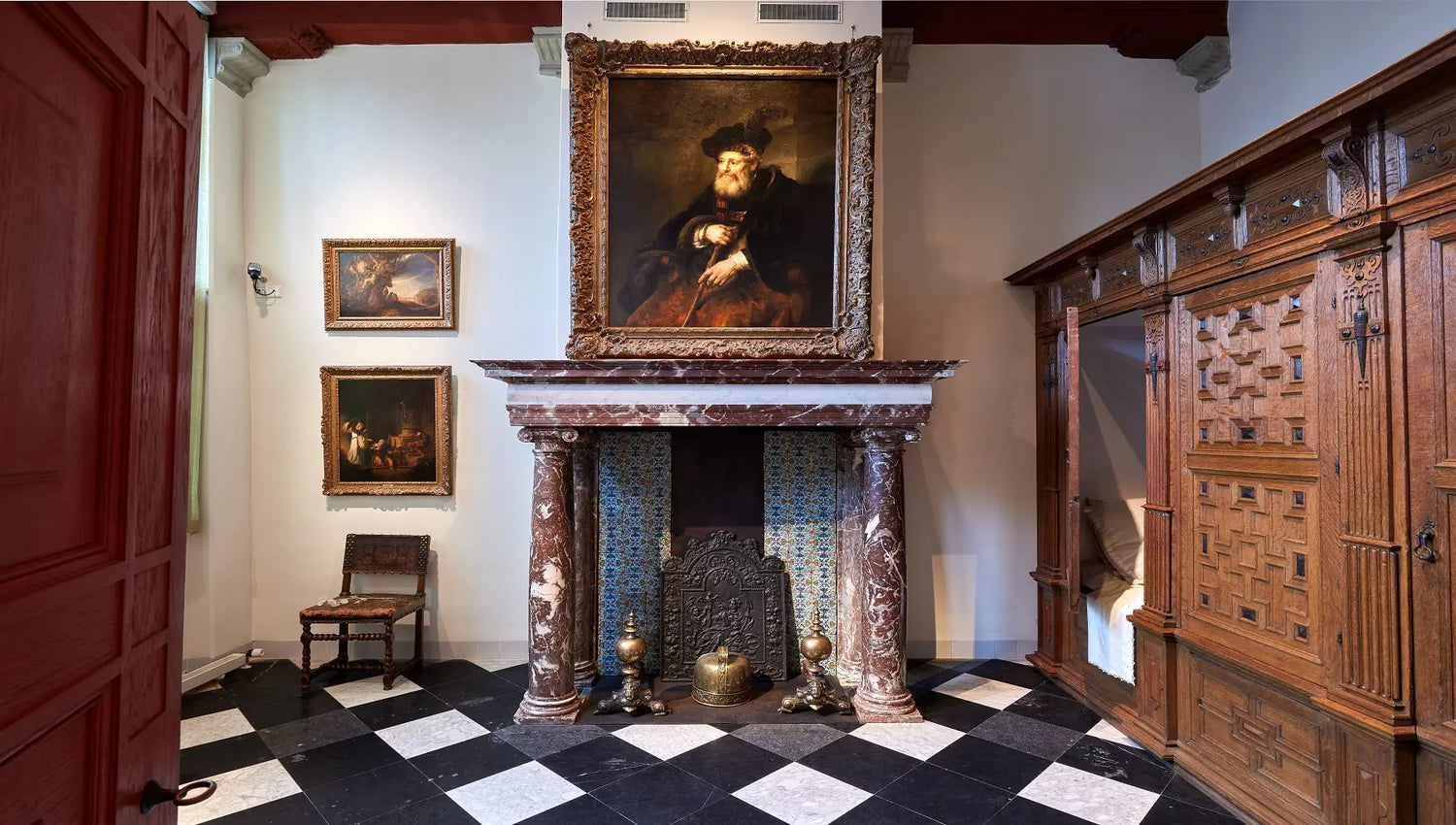 Interior of the Rembrandthuis Museum in Amsterdam featuring 17th-century furnishings, wooden beams, and artist tools recreating Rembrandt’s living and working space