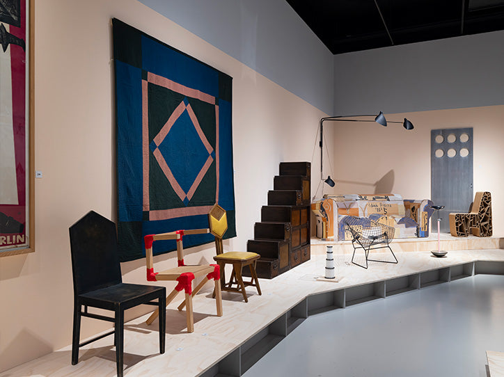 Exhibition view of Trans Europa Design Express, showcasing modern European design objects displayed in a dynamic, train-inspired setting with colorful lighting and interactive elements.