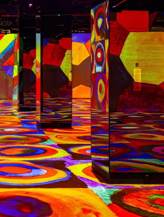 Vibrant digital composition inspired by Kandinsky’s abstract style, created by Mark Zhelezoglo for Hall des Lumières. The image features dynamic geometric shapes, bold colors, and layered textures, evoking movement and rhythm. Projected in an immersive format, it reflects the fusion of modern digital art with early 20th-century abstraction.